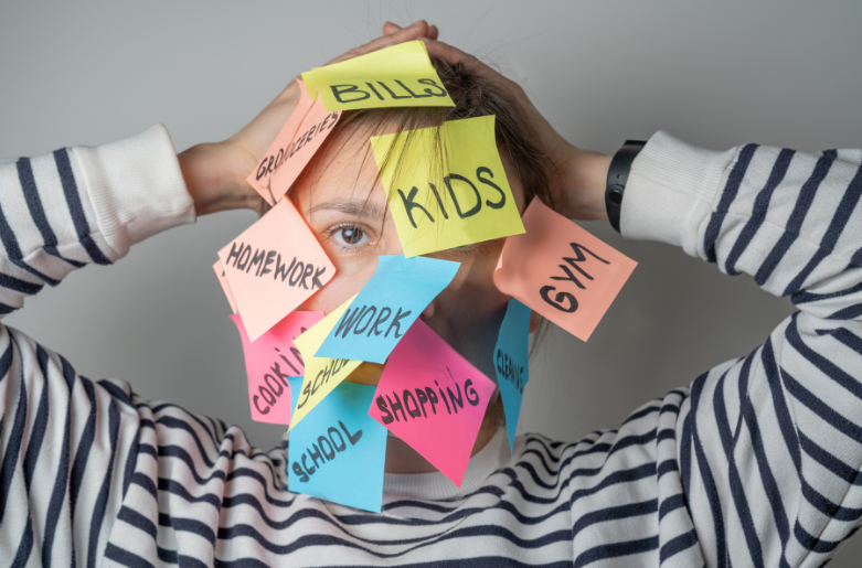 Porträt einer Frau mit Händen hinter dem Kopf und mit Post-Its auf dem Gesicht mit Stichwörtern auf Englisch wie Kinder, Arbeit, Einkauf