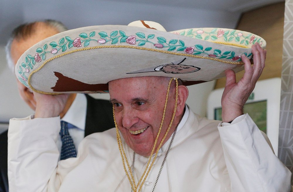 Papst Franziskus mit Sombrero / Copyright 2016, KNA. Alle Rechte vorbehalten, Paul Haring Papstreise nach Mexiko mit einem Zwischenstopp in Kuba. Bild: Papst Franziskus lacht und setzt sich am 12. Februar 2016 auf dem Flug nach Havanna einen Sombrero auf.