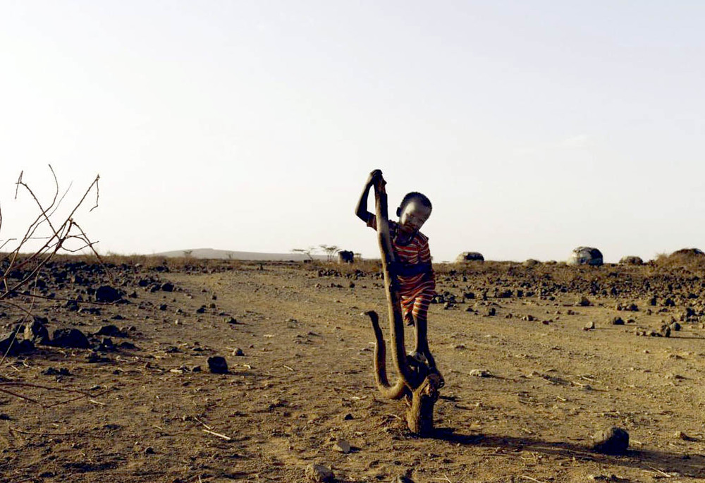 Afrikanisches Kind in trockener Landschaft / Caritas Afrikanisches Kind in trockener Landschaft