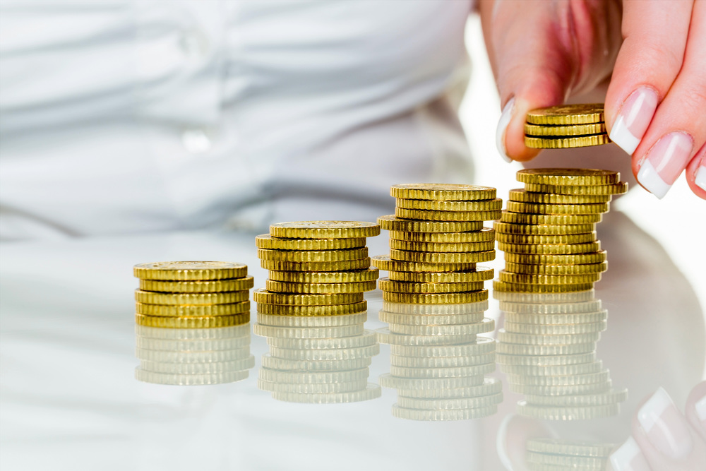 Frau mit Münzstapel beim Geld sparen / Erwin Wodicka - wodicka@aon.at