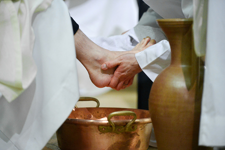Ein Geistlicher trocknet einem Mann mit einem Handtuch den Fuß während der Fußwaschung an Gründonnerstag, am 24. März 2016 in der Kirche Saint-Jean-Baptiste de Belleville in Paris.